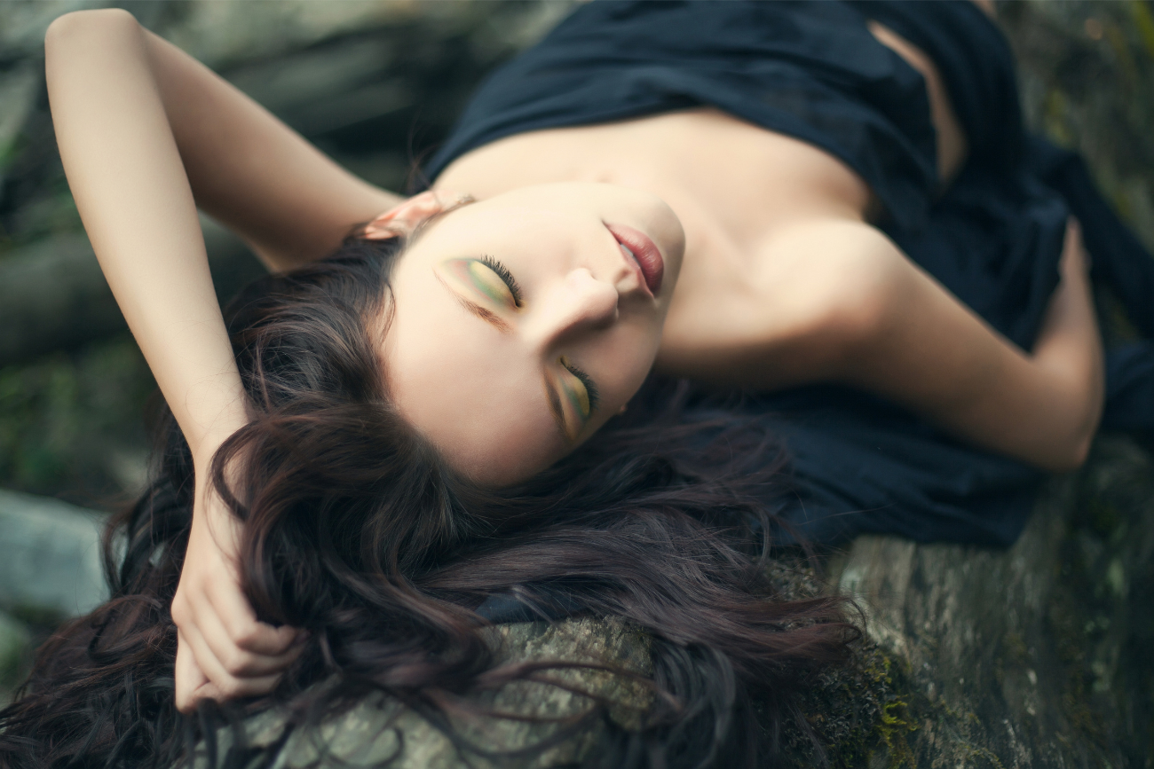 healthy-skin-happy-life-woman-blissfully-laying-on-a-log-in-the-woods