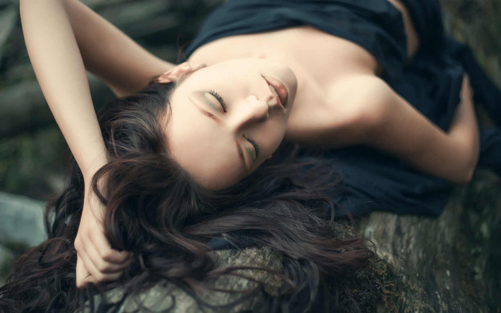 Rewild and reconnect with self and nature woman laying on a fallen log in the forest